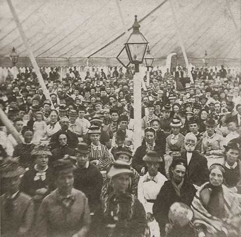 In this photo people assemble under a tent to hear an evangelist on Martha's Vineyard (USA) in the 1800's.